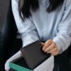 ギフトボックスに入った黒い革財布を開ける女性