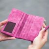 女性が手に持って開いたピンク色の財布