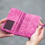 女性が手に持って開いたピンク色の財布