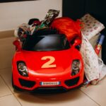 包装された贈り物と赤い乗用玩具の車