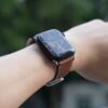 革ベルトを付けたスマートウォッチを着けた手首
