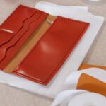 白い布の上に並べた赤と茶色の二つの財布
