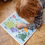 床に広げたパズルに取り組む子ども