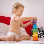 カラフルな積み木を重ねて遊ぶ赤ちゃん
