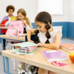 教室の机に水筒を置いて過ごす小学生