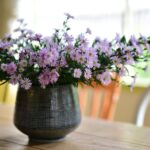 テーブルに置いた花瓶いっぱいの紫色の花