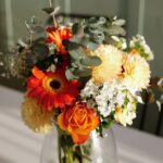 秋色の花をまとめた花束を花瓶に生けた様子