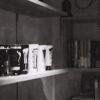 モノトーンの棚に並べたコーヒー器具とインテリア小物