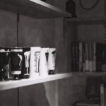 モノトーンの棚に並べたコーヒー器具とインテリア小物