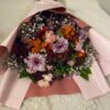 ピンクの包装紙で包まれたダリアの花束