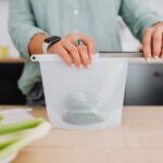 シリコーン製保存バッグに野菜を詰めている手元