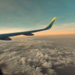 飛行機の翼越しに見える夕焼けと雲海