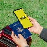 スーツケースの持ち手に手を添えながらスマートフォンを操作する様子