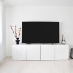 白い壁の部屋に置いた白いテレビボードと大型テレビ