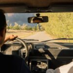 後部座席から見た、田舎道を走る車の運転席と助手席