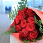 赤い包装紙で包んだ真っ赤なバラの花束