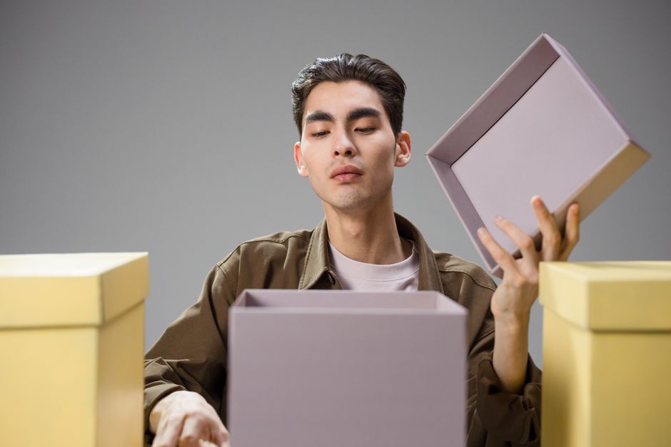 プレゼントの箱を開けて浮かない表情を見せる男性