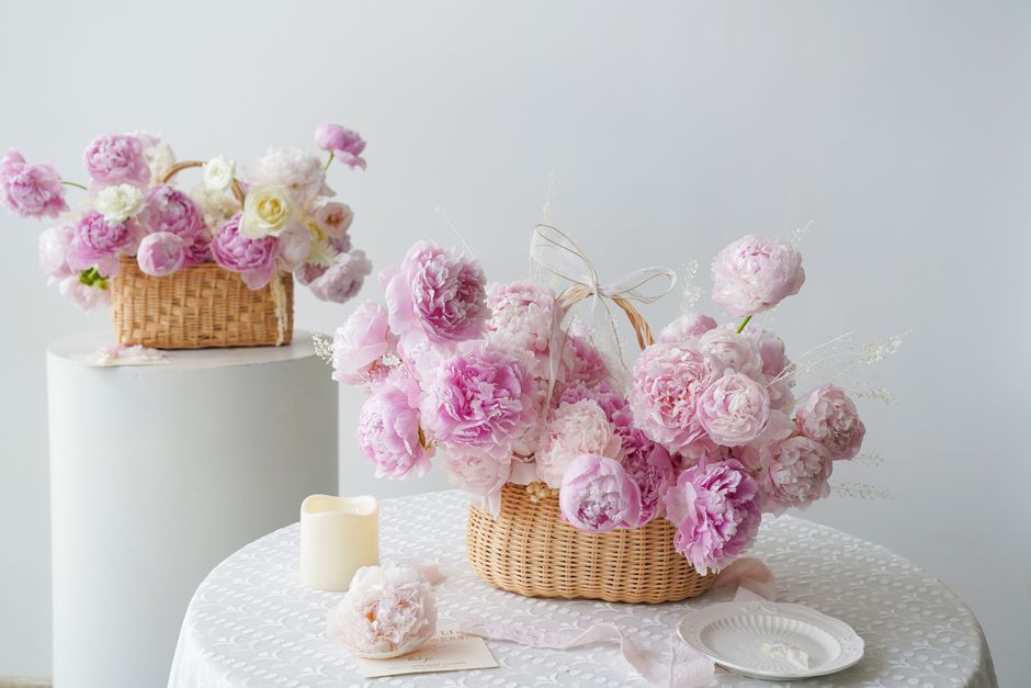 白いテーブルに飾ったピンクの花のバスケットアレンジメント